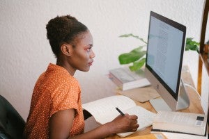 woman making notes at a computer