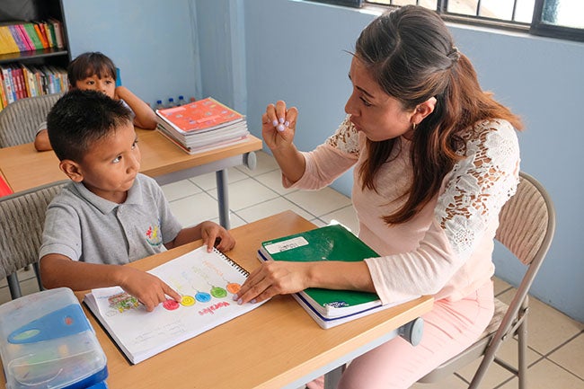 Teacher aide helping student