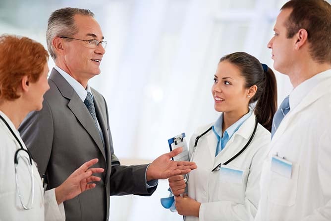 Business man and doctors communicating in the hospital.    