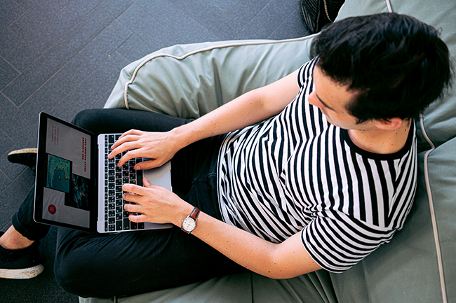 man in striped shirt on laptop