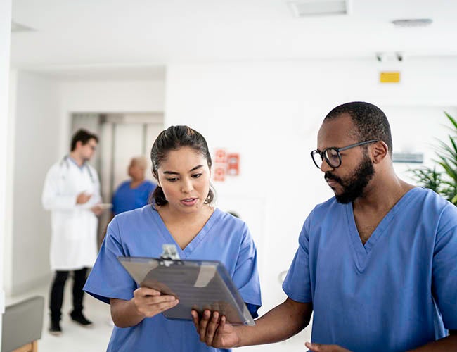 Nurses walking and talking at corridor hospital