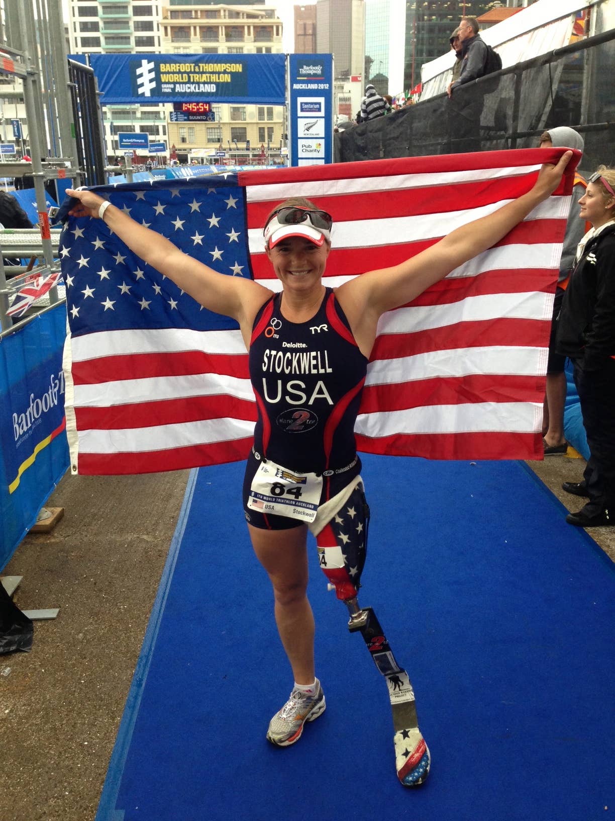 Melissa Stockwell holding an American flag at a triathlon
