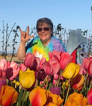 Kim Larsen smiling behind lots of tulips