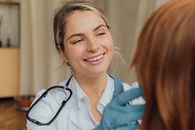 Nurse checking ear of patient